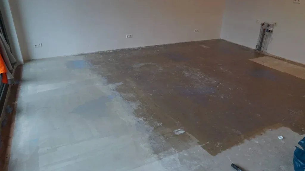 Kale ondervloer met resten van de oude vloerafwerking